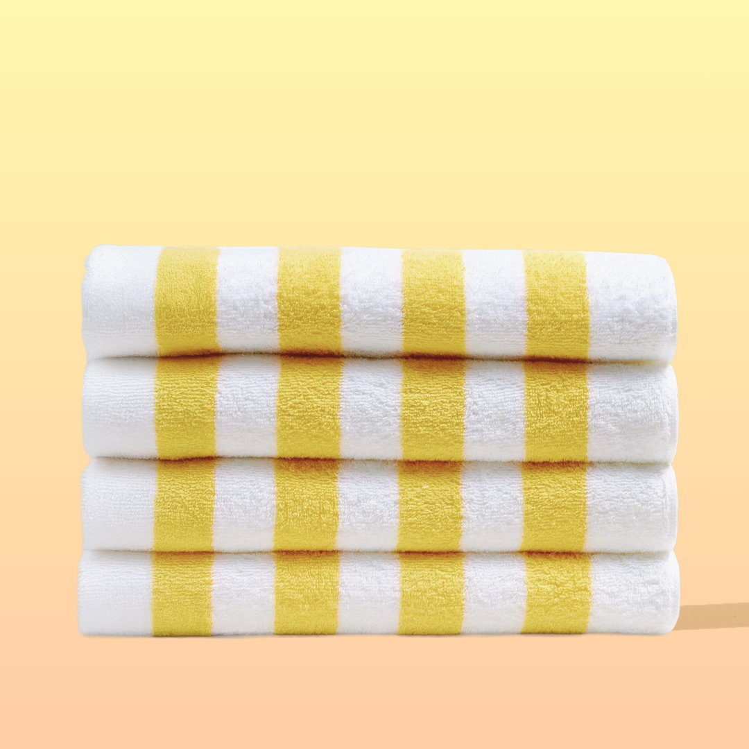 Three folded towels with yellow and white stripes on a yellow background