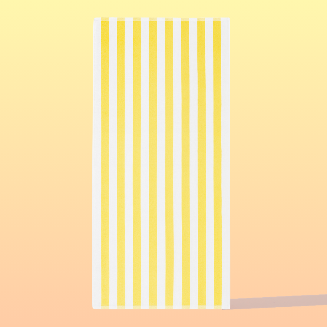 Striped towel with yellow and white stripes on a peach background